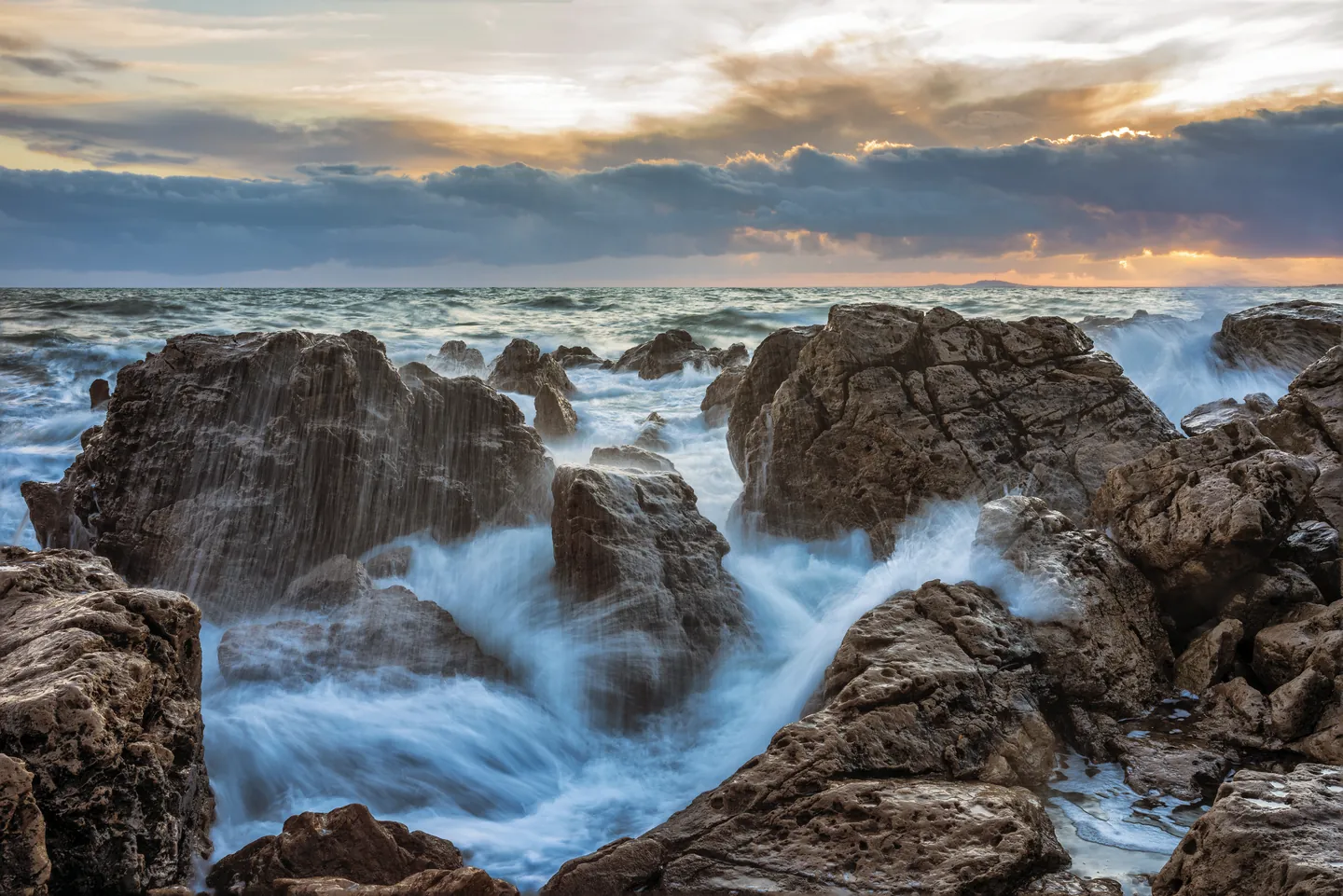 Vagues sur les rochers de la Corniche à Sète, en France, au coucher du soleil